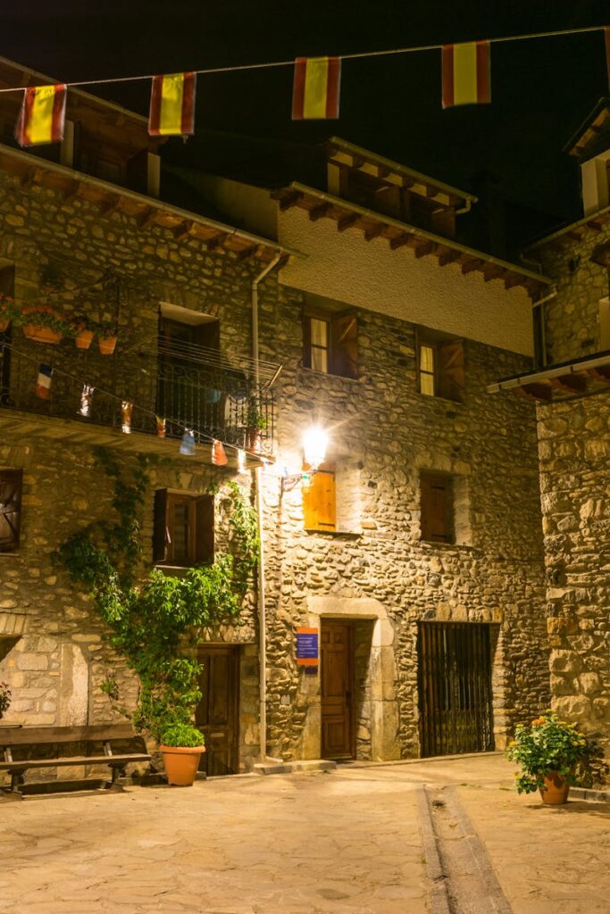 Stone buildings and festive decorations in Benasque, Spain at night.